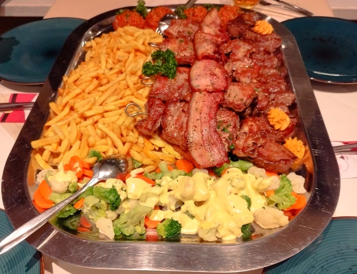 Große Grillplatte mit Ćevapčići, Bauchspeck, Gemüse und Pommes frites