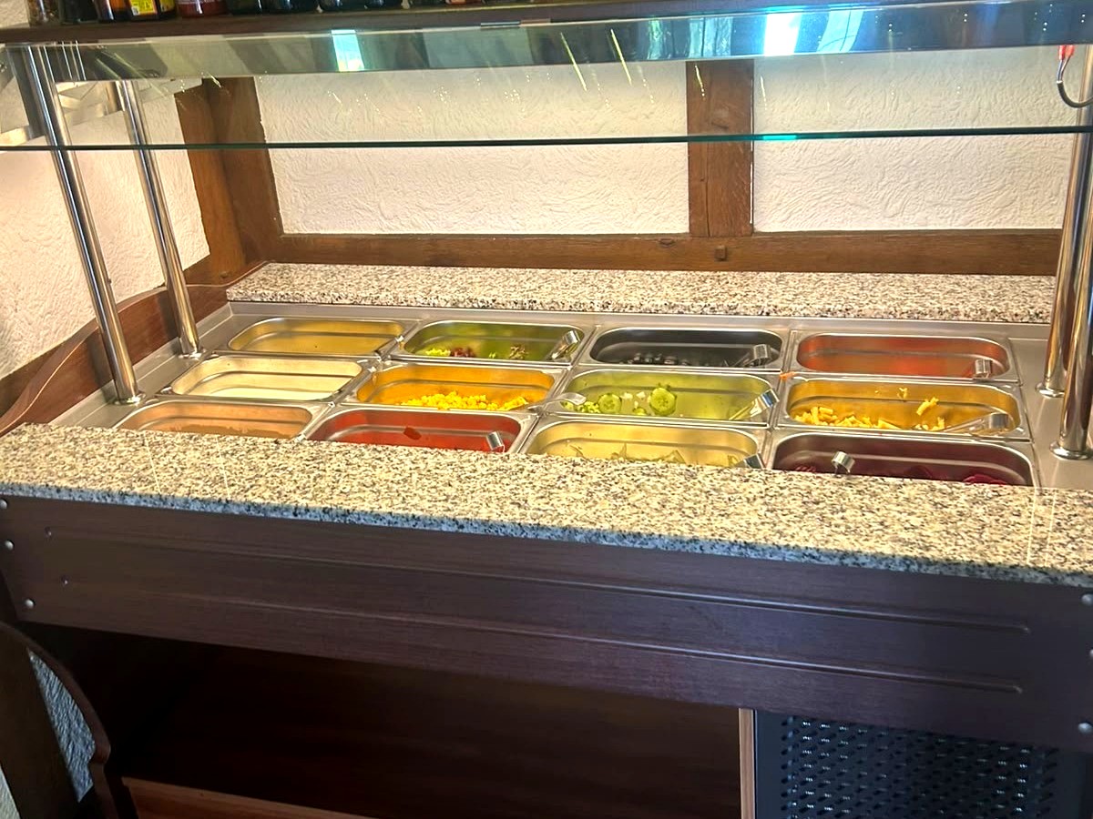 Das Salatbuffet mit Schüsseln voller Zutaten und Dressings