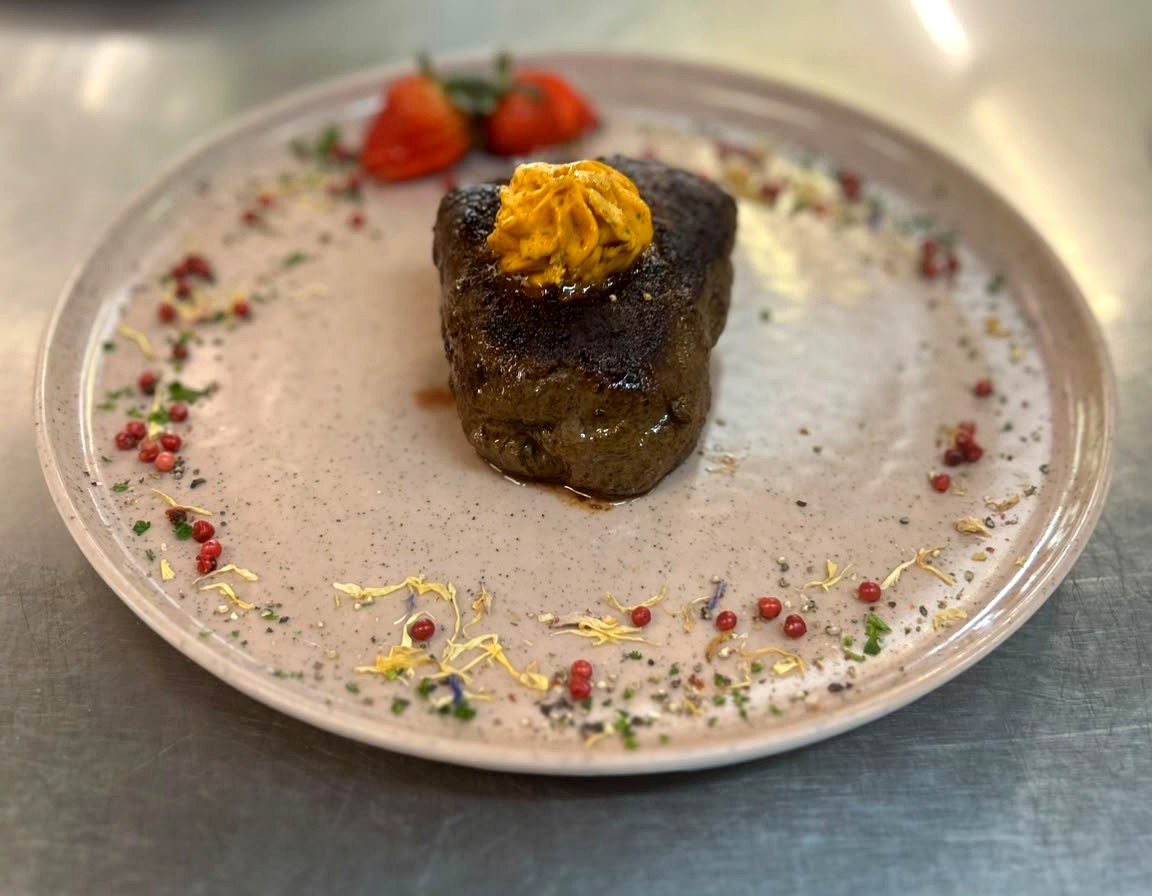 Filetsteak mit Kräuterbutter, angerichtet auf hellem Teller